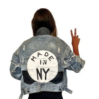 Lighter blue denim wash. White circle, painted MADE IN NYC inside in black.  Pockets and hems painted black Signed @wrenandglory.