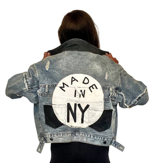 Lighter blue denim wash. White circle, painted MADE IN NYC inside in black.  Pockets and hems painted black Signed @wrenandglory.