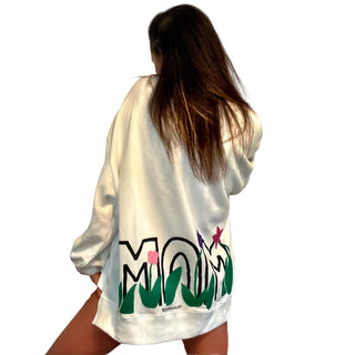Oversized white sweatshirt. 'MOM' painted in on back, coming up from bottom hem, with flower pattern painted throughout letters. Customized upper back with names of children, grandchildren, husband, etc. Up to 8 names able to be painted. Small red embroidered heart on each lower sleeve. Signed @wrenandglory.