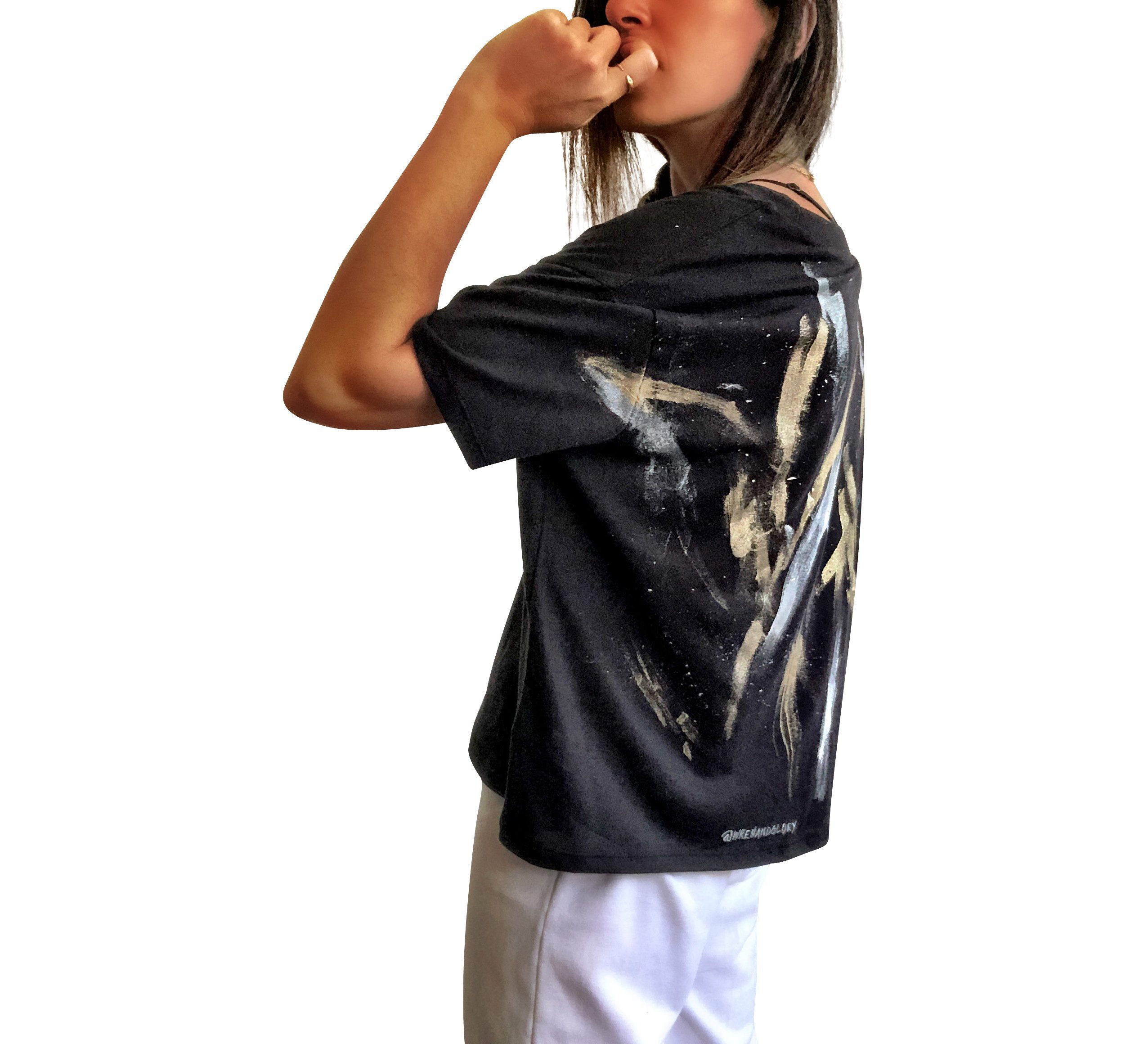 The perfect cropped black T shirt. Assorted color metallics and white splatter and stripes painted on back, with small stars painted on front, upper left side in gold. Signed @wrenandglory.