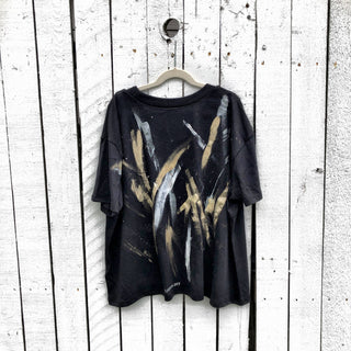 The perfect cropped black T shirt. Assorted color metallics and white splatter and stripes painted on back, with small stars painted on front, upper left side in gold. Signed @wrenandglory.