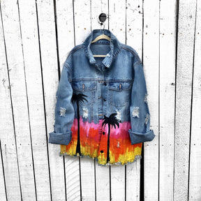 Medium blue denim wash. Heavily inspired by Coachella with ombre sunset colors painted along entire bottom half of jacket, with black silhouettes of Palm Trees surrounding. Button painted black. Signed @wrenandglory.