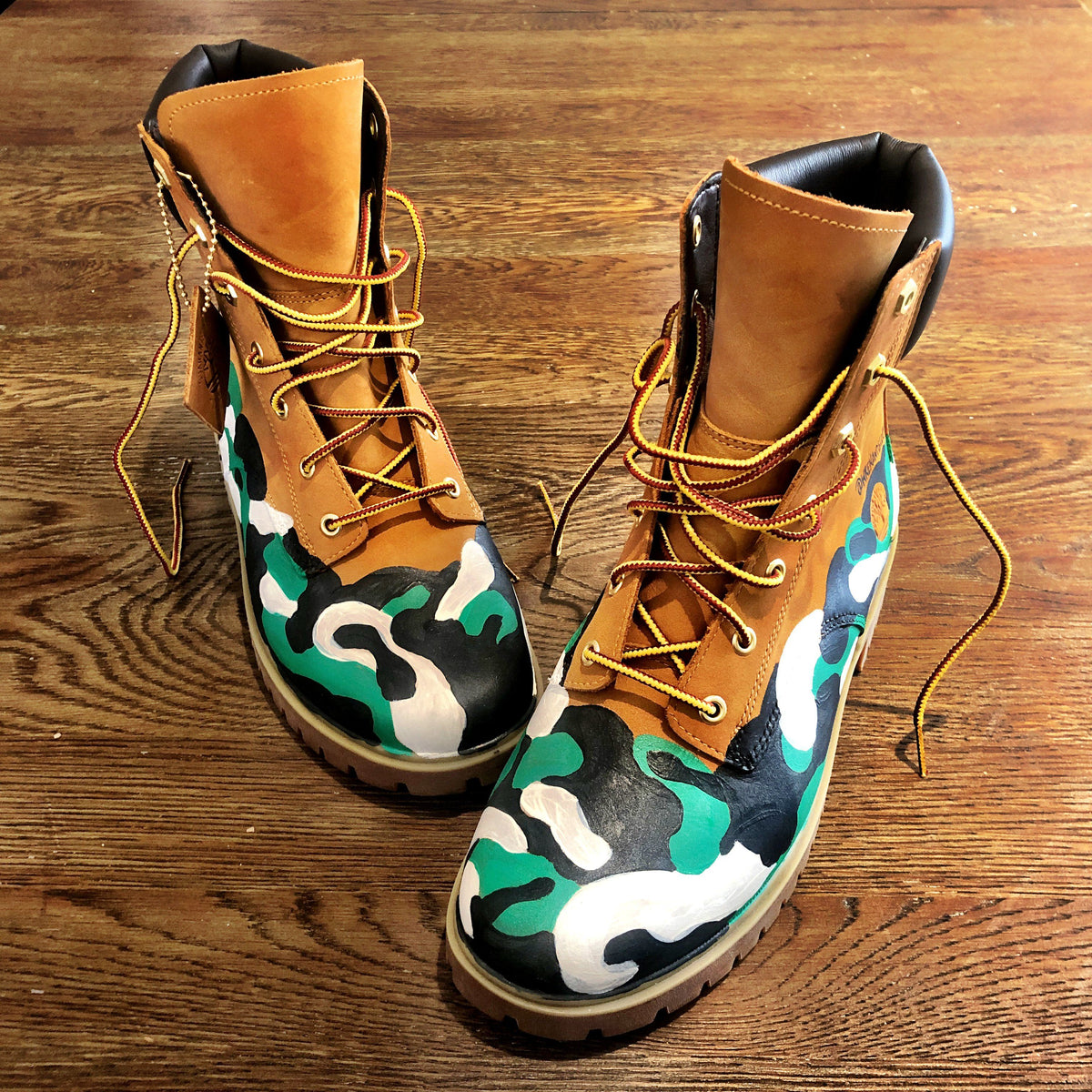 Green, white and black camo style painted boots. Painted on waterproof Timberland Boots. Signed @wrenandglory. 
