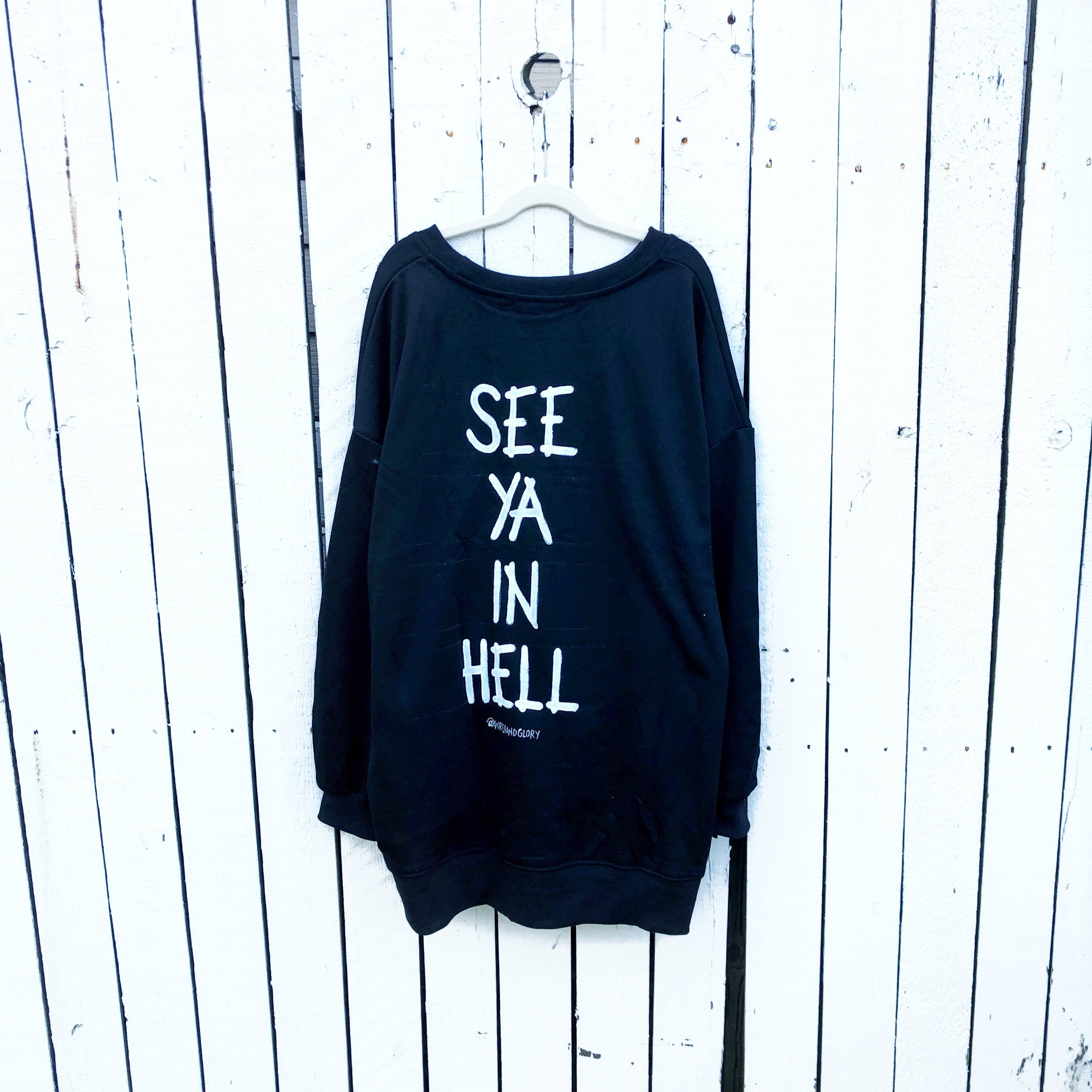 Oversized black sweatshirt. SEE YA IN HELL painted on back in white, silhouette of devil painted on front upper side.  Signed @wrenandglory.