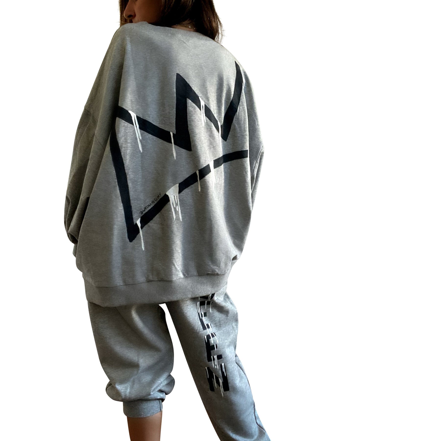 The perfect oversized sweatshirt & jogger loungewear set. TOP: Large crown painted on back in black, with white paint drips. QUEEN painted in black, on front left chest. BOTTOM: QUEEN painted on back going down leg in black, with white paint drips. Assorted sized crowns painted in black and white on front. Signed @wrenandglory on both top and bottom.