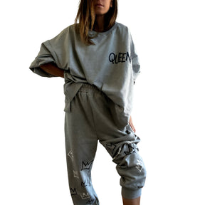 The perfect oversized sweatshirt & jogger loungewear set. TOP: Large crown painted on back in black, with white paint drips. QUEEN painted in black, on front left chest. BOTTOM: QUEEN painted on back going down leg in black, with white paint drips. Assorted sized crowns painted in black and white on front. Signed @wrenandglory on both top and bottom.