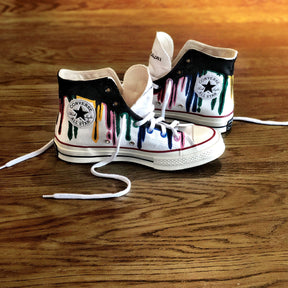 Black and rainbow colored white, canvas sneakers. DONT KNOW painted on one, DONT CARE painted on other. Painted on Converse high tops, Chuck Taylor All Star '70 High.