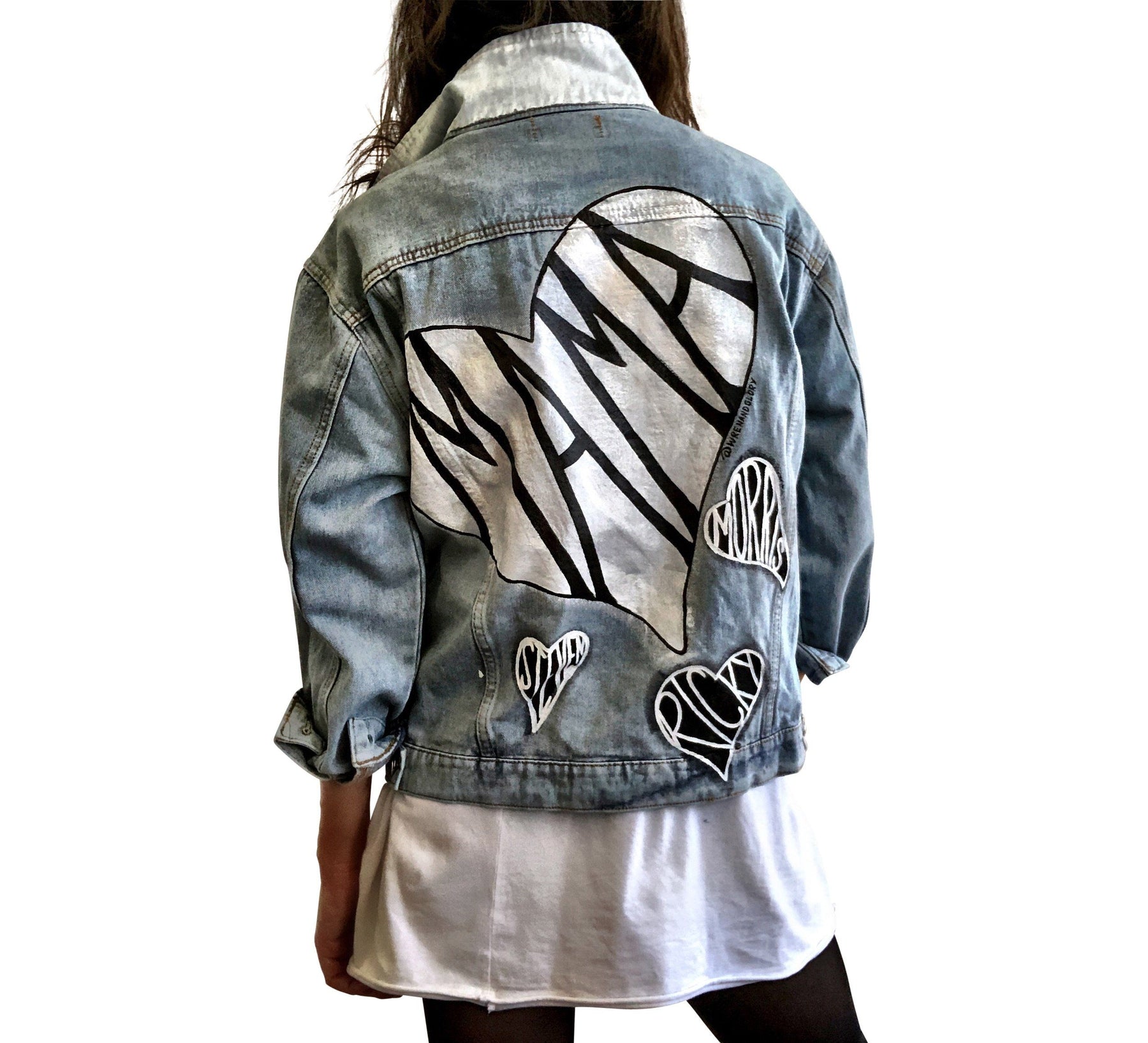 Lighter blue denim wash. Large white heart on back with MAMA painted inside in black. Smaller black hearts surrounding the larger one, customized with kids names. Collar and front pockets painted white. Signed @wrenandglory.